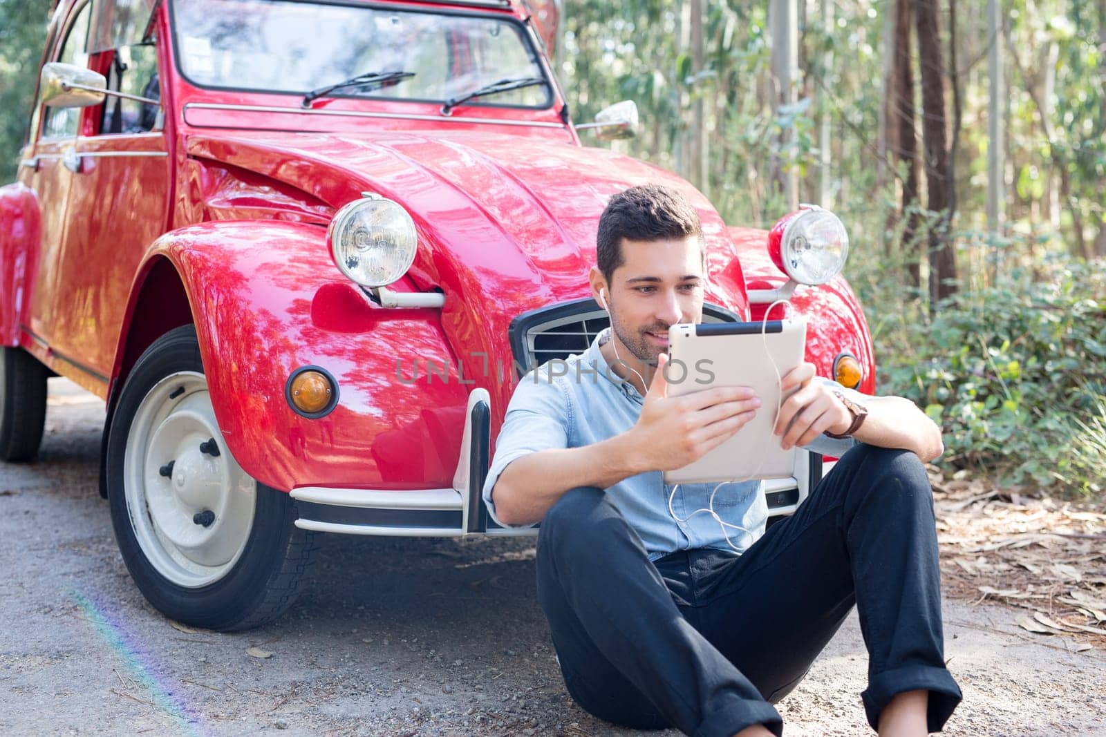 Young man resting at car trip by the countryside