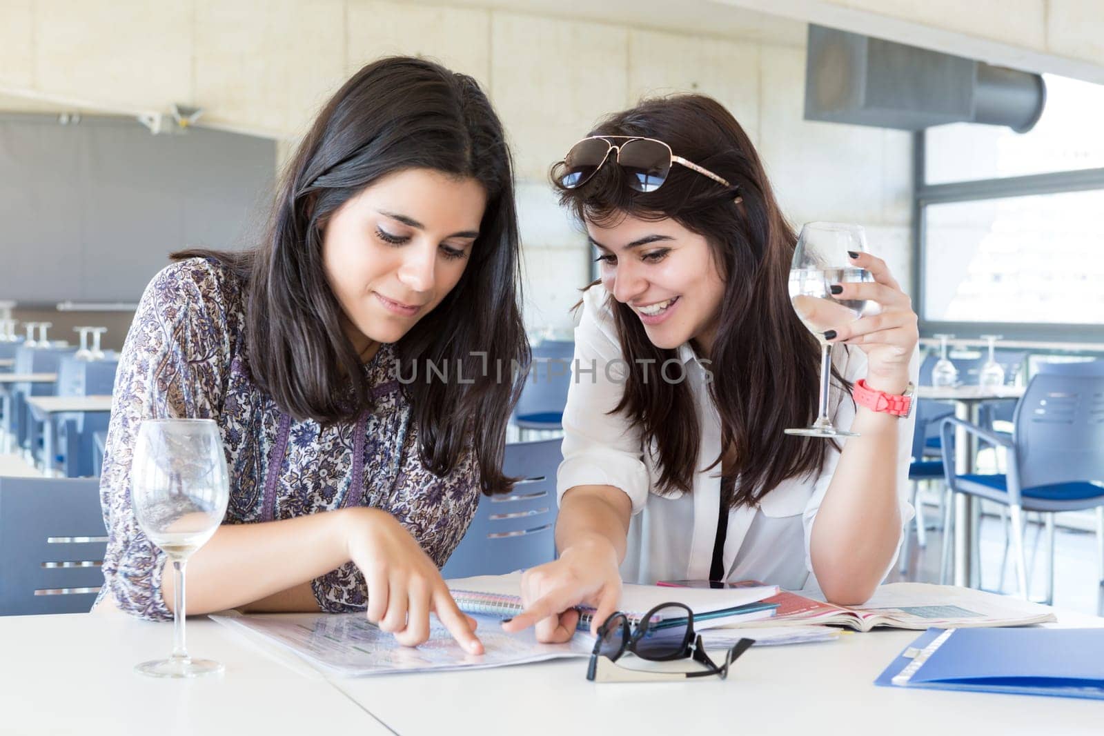 Group of happy students preparing their exams or simply relaxing at a bar