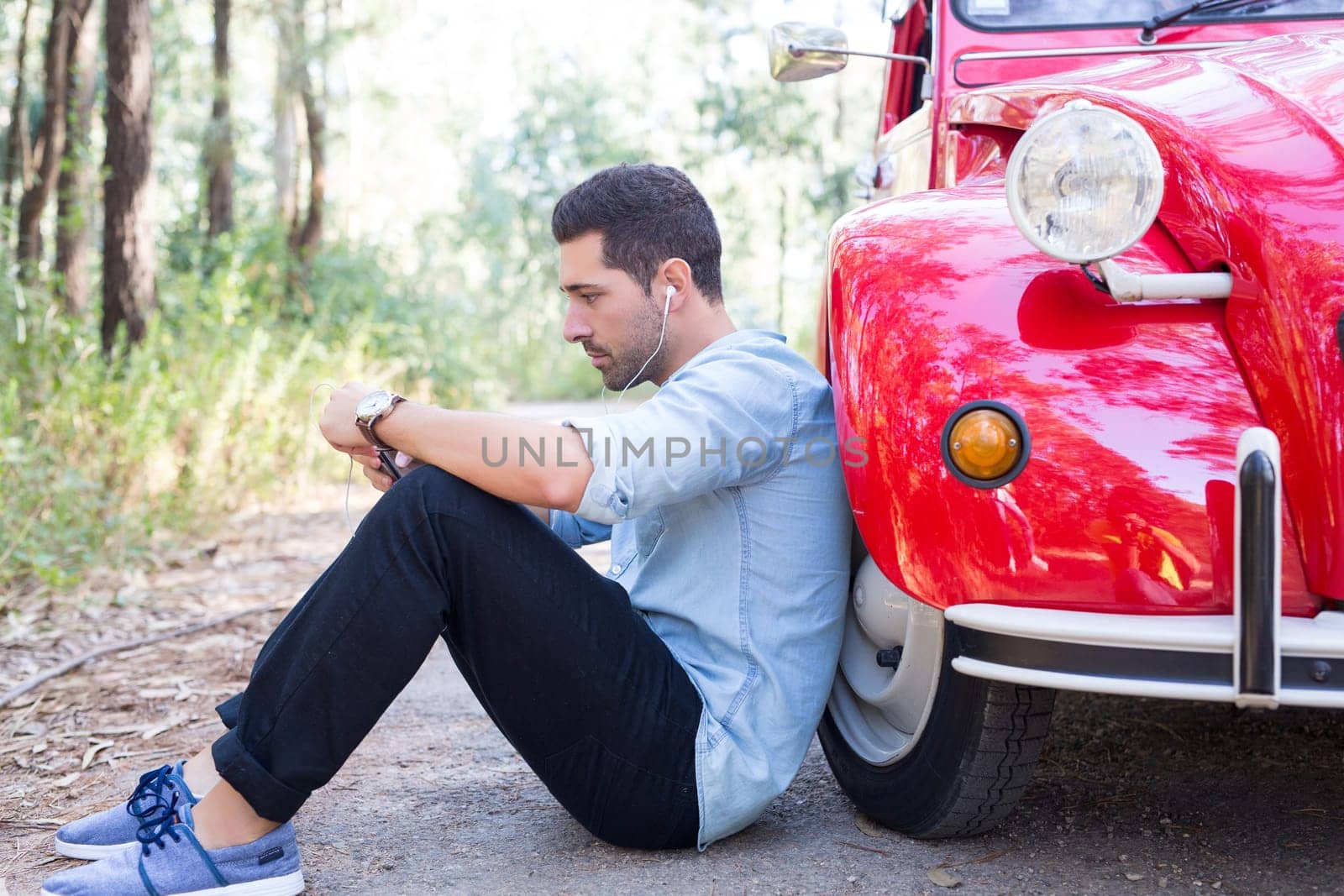 Young man resting at car trip by the countryside