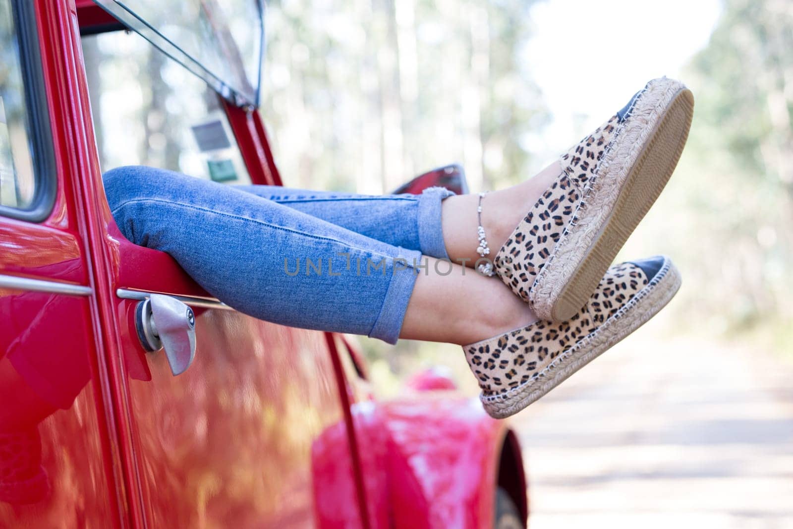 Woman on a roadtrip relaxing in her convertible car