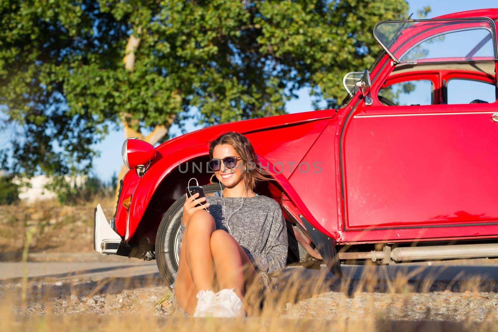 Young woman resting at car trip by the countryside