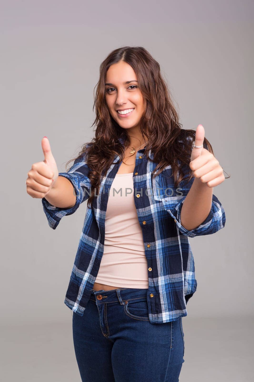 Beautiful young woman signaling ok, isolated over white
