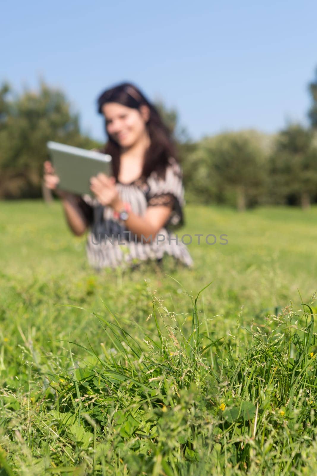A beautiful young woman relaxing at the city park - Selective focus on the grass