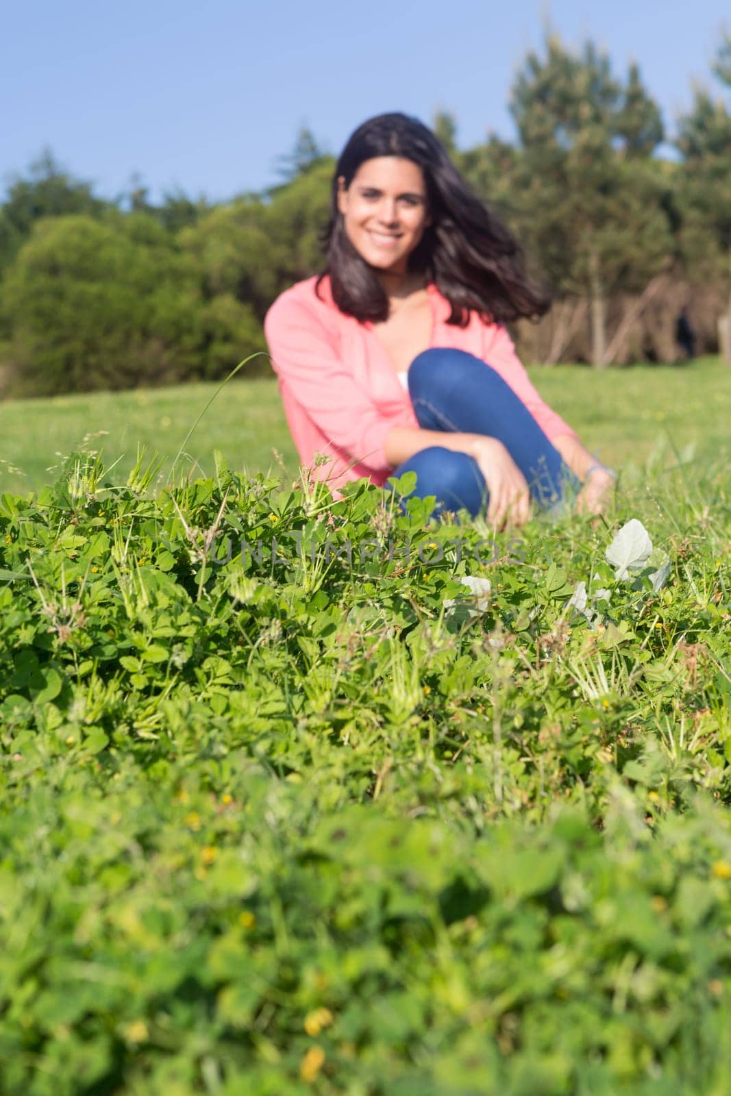 A beautiful young woman relaxing at the city park - Selective focus on the grass