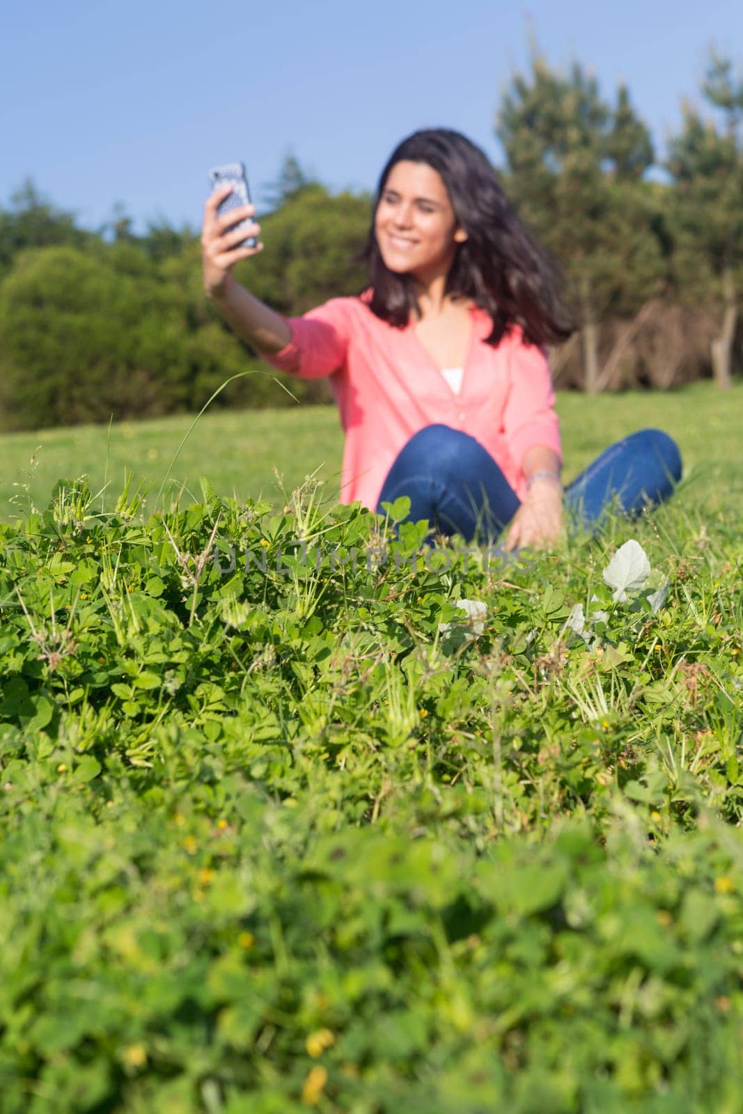 A beautiful young woman relaxing at the city park - Selective focus on the grass