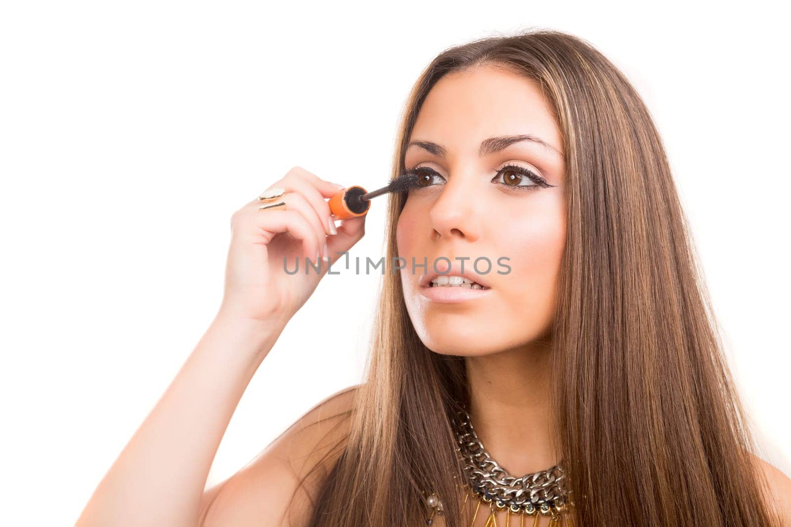 Beautiful young woman applying makeup