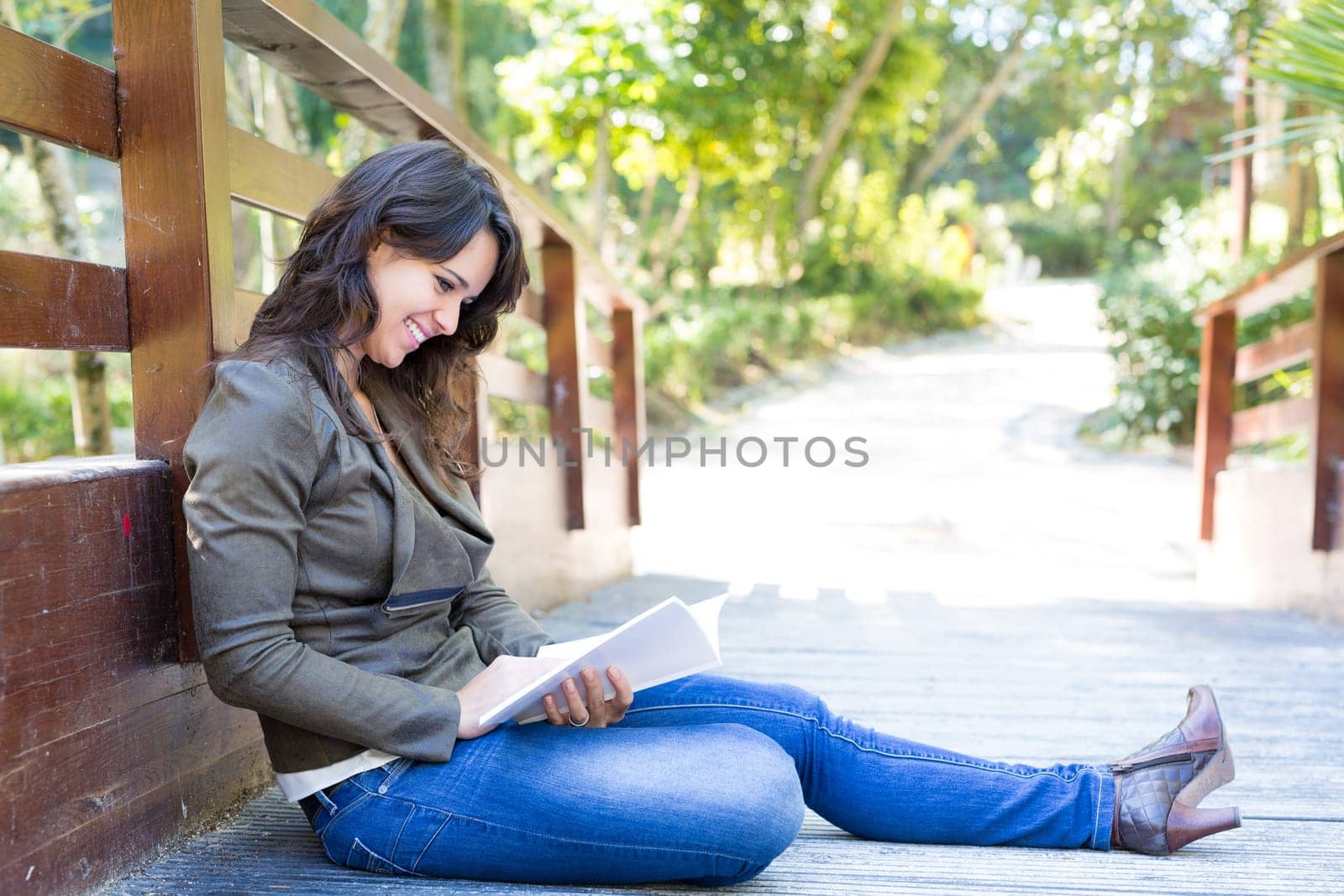 Young woman reading a book and relaxing at the park