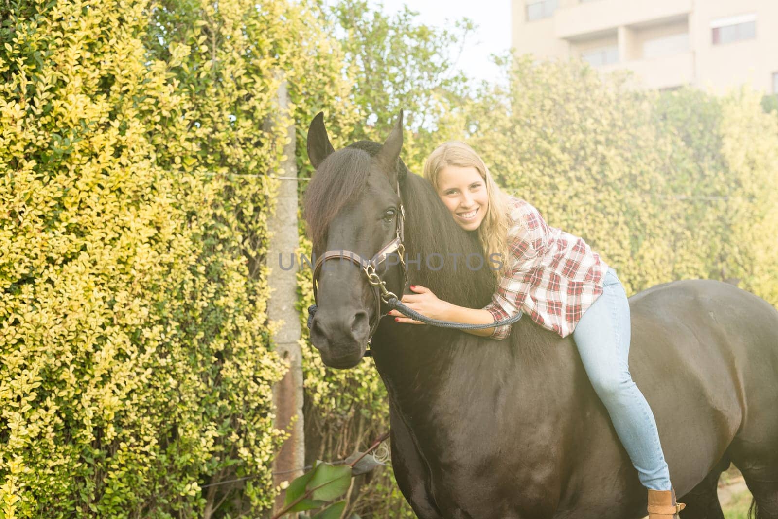 Beautiful and natural young woman spending sometime with her horse