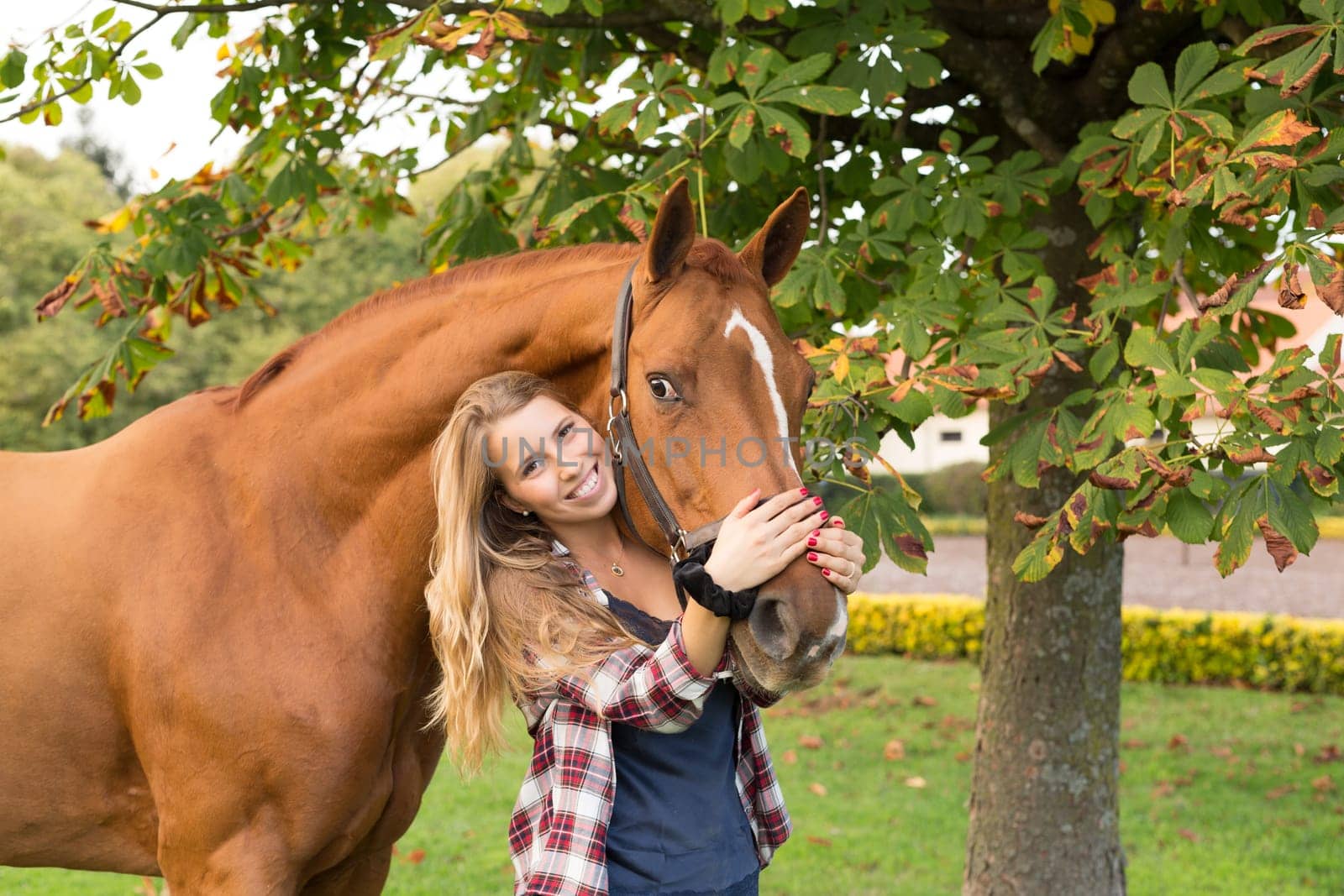 Beautiful and natural young woman spending sometime with her horse