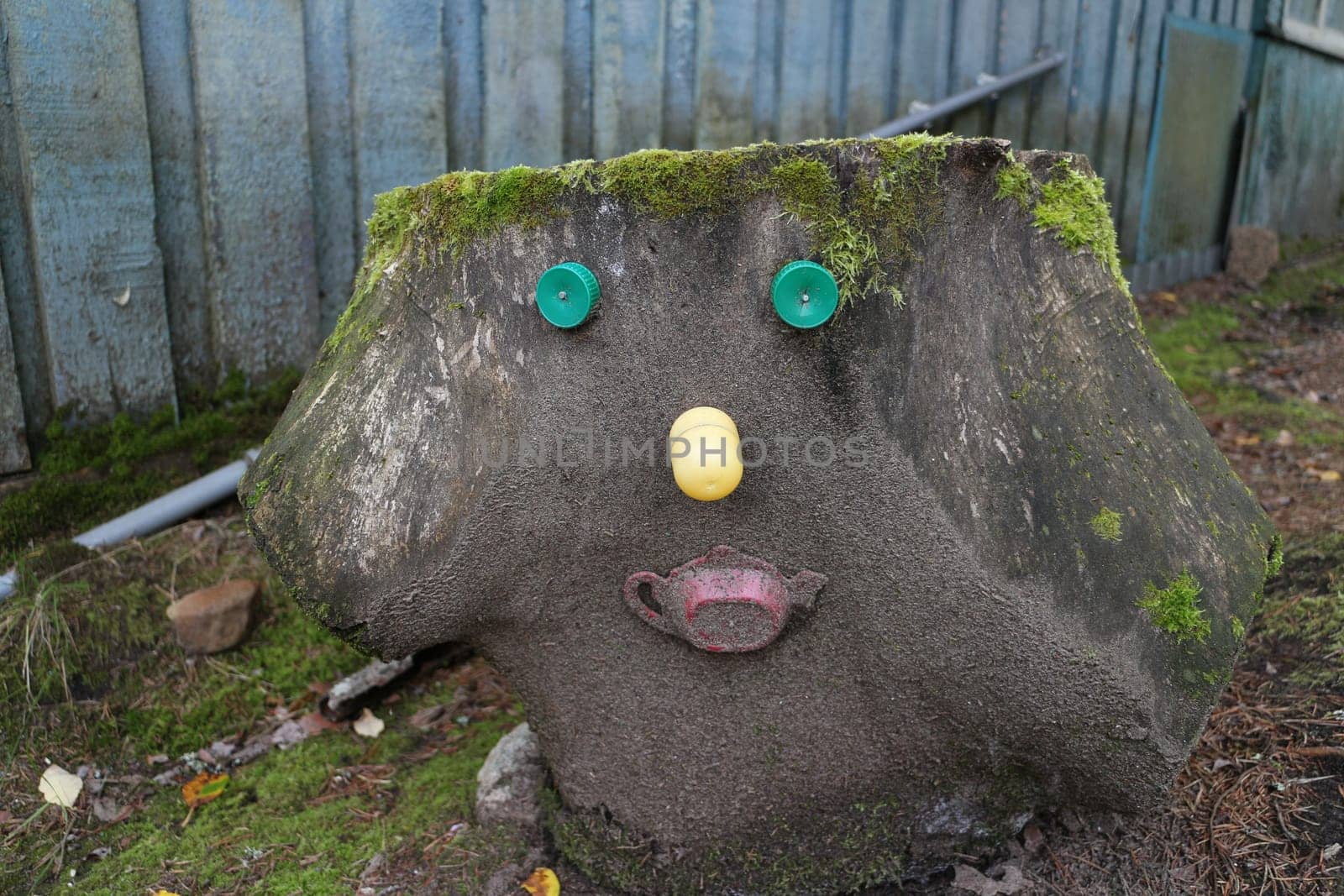 tree stump forest spirit with funny face, decorated with trinkets