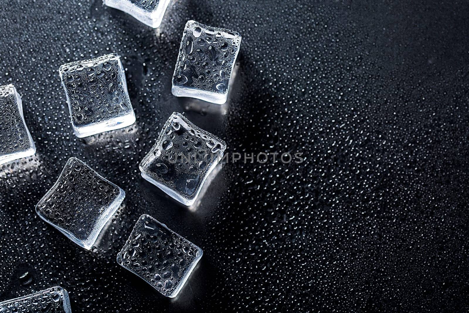 Ice cubes on black color texture. Concept art. Minimal surrealism. Flat lay with copy space. Soft focus.