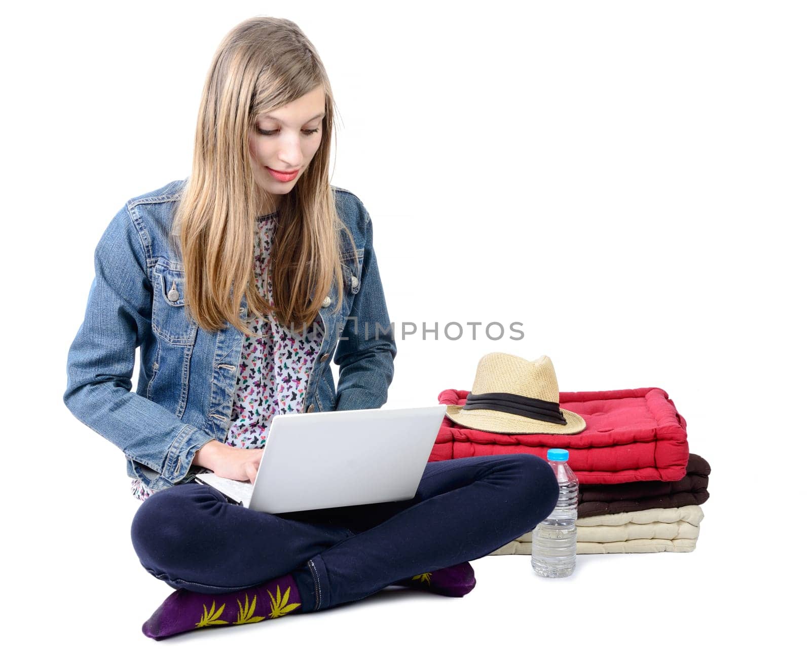 teenage girl seated with a laptop on white background