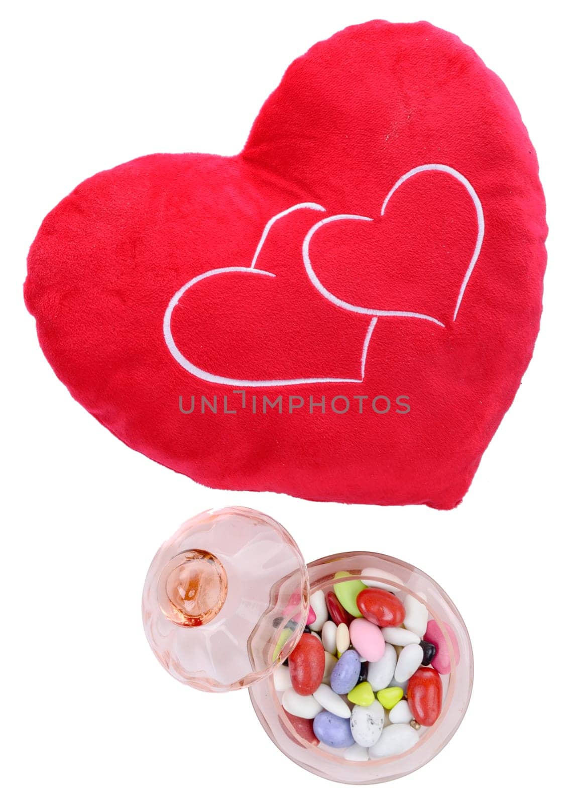heart shaped cushion with candy on the white background