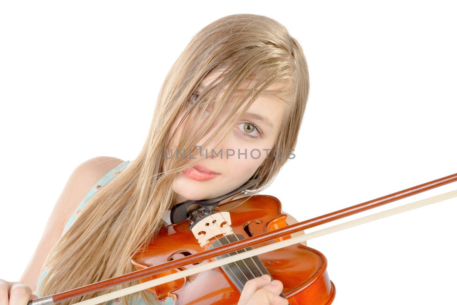 a teenage girl with long hair plays violin on the white background