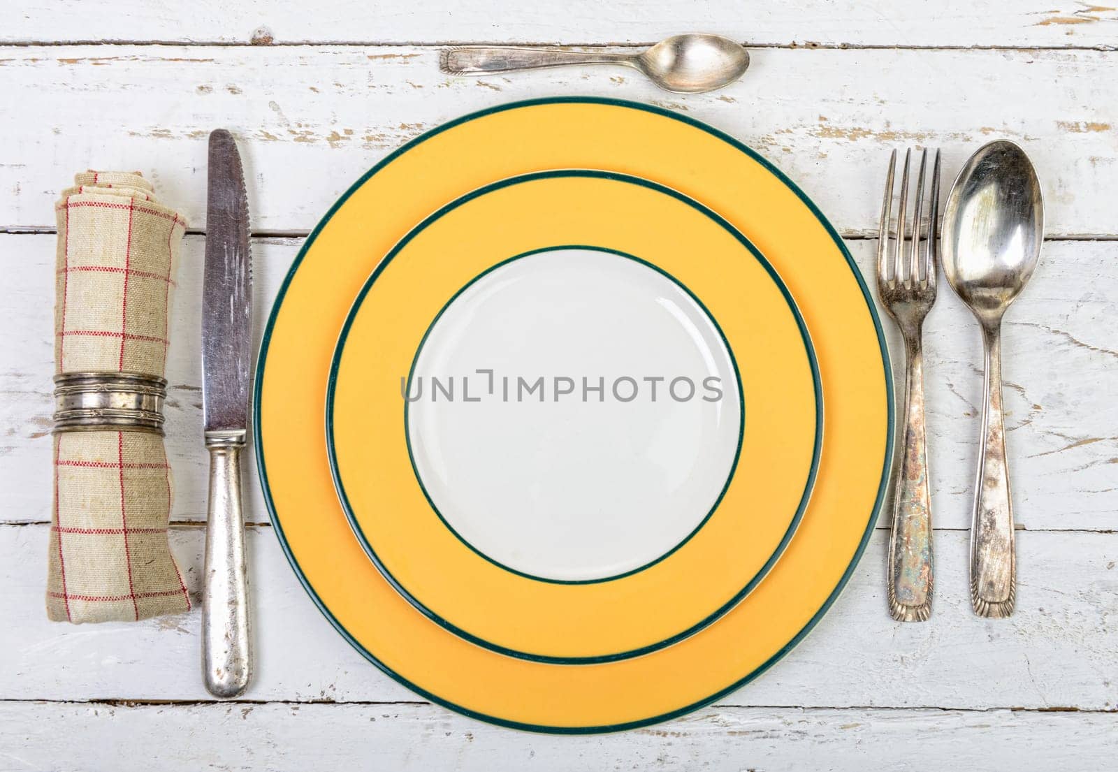 plate with silver cutlery on an old white table