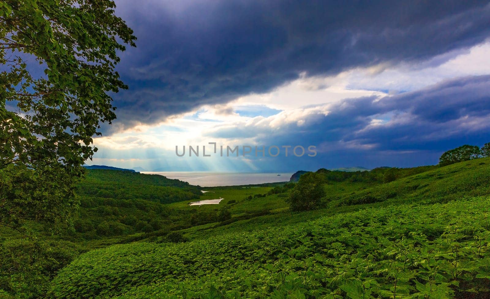 moody and atmospheric image with view of the lake and clouds with sun rays