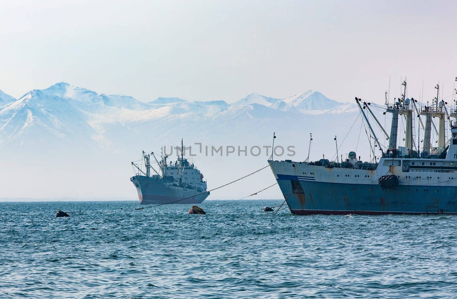 large fishing vessel on the background of hills and volcanoes