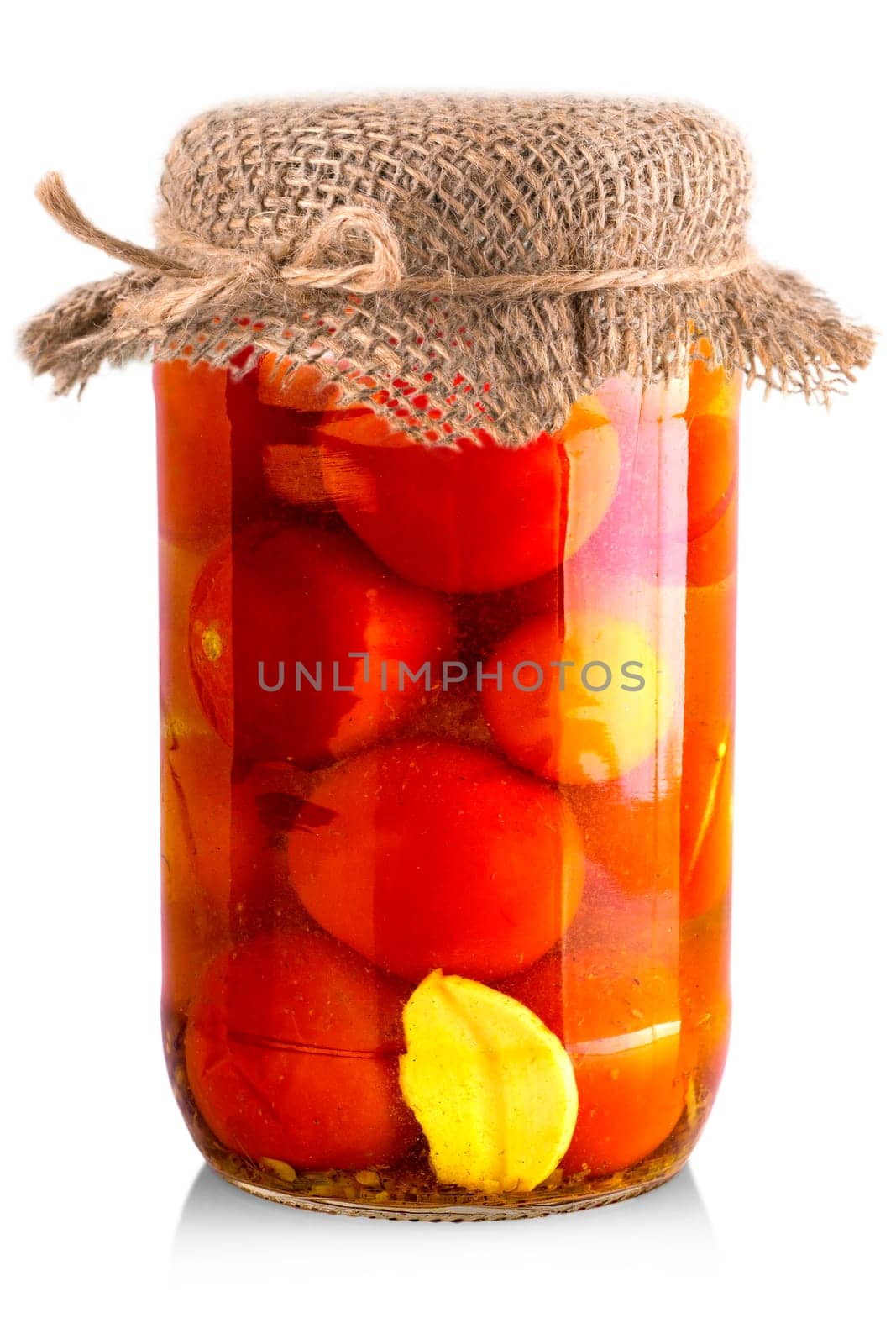 Pickled red and yellow tomato in glass isolated on white background.