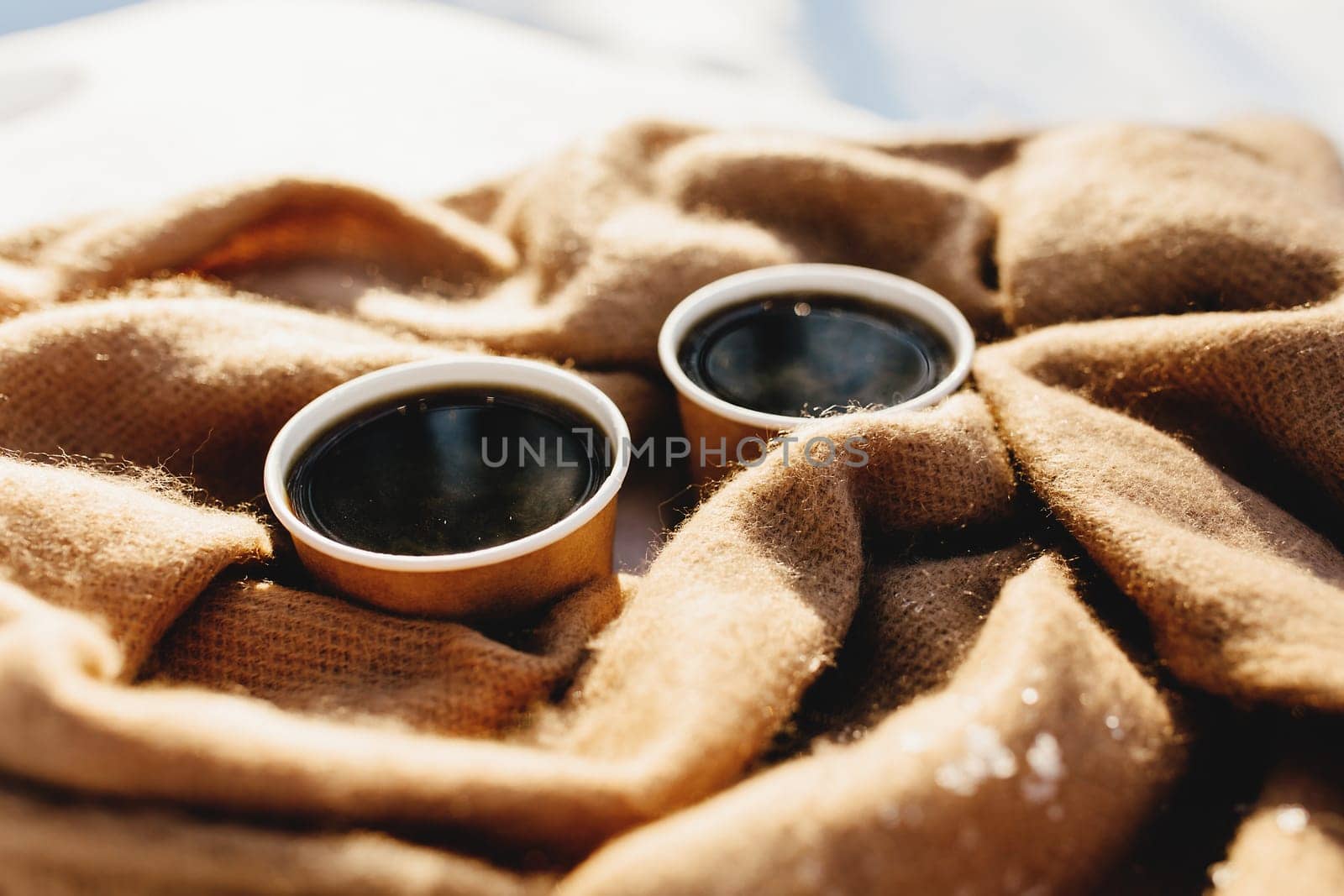 Two cups of coffee on a scarf in the snowy forest. High quality photo