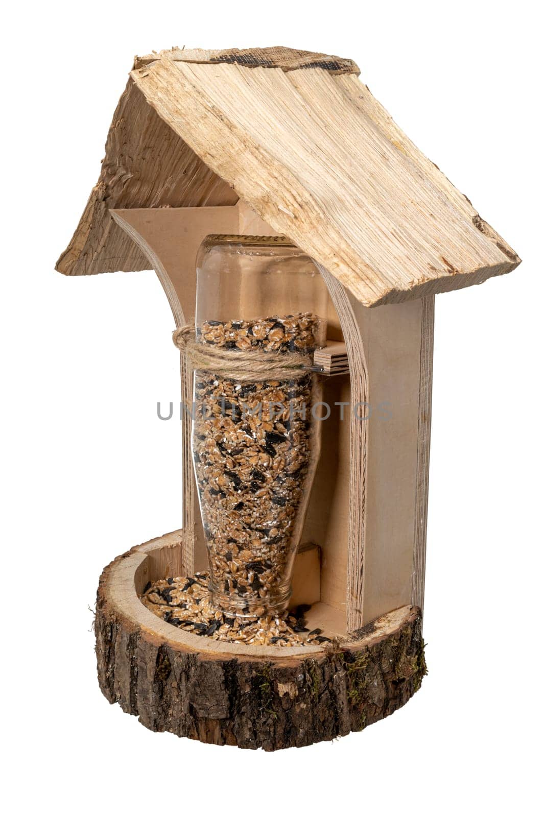 Self-made wooden bird feeder with glass bottle and bird seed i