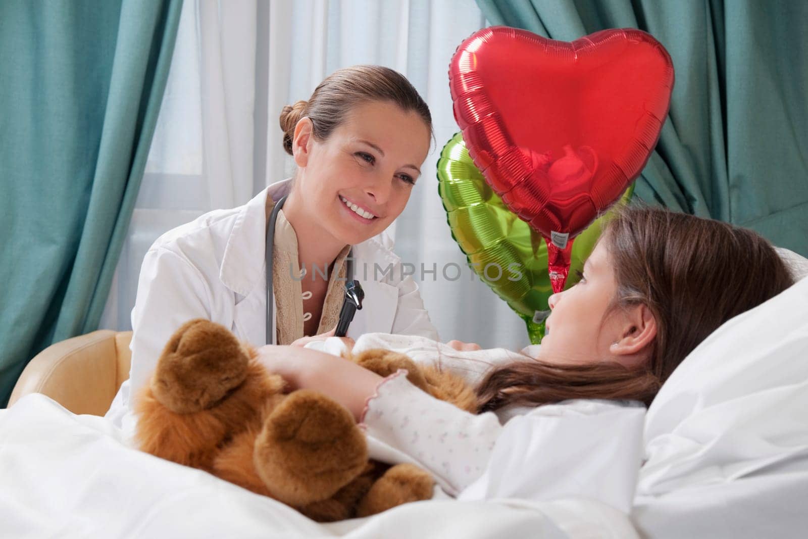 Female doctor talking with a girl in a hospital ward