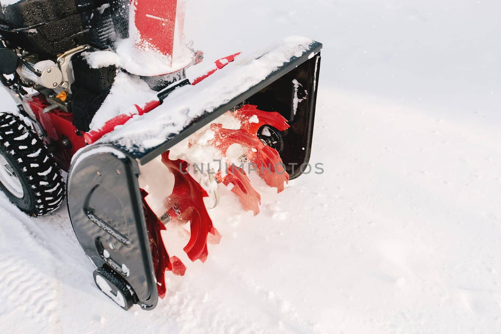 Red-black snowblower machine in the process of work. High quality photo