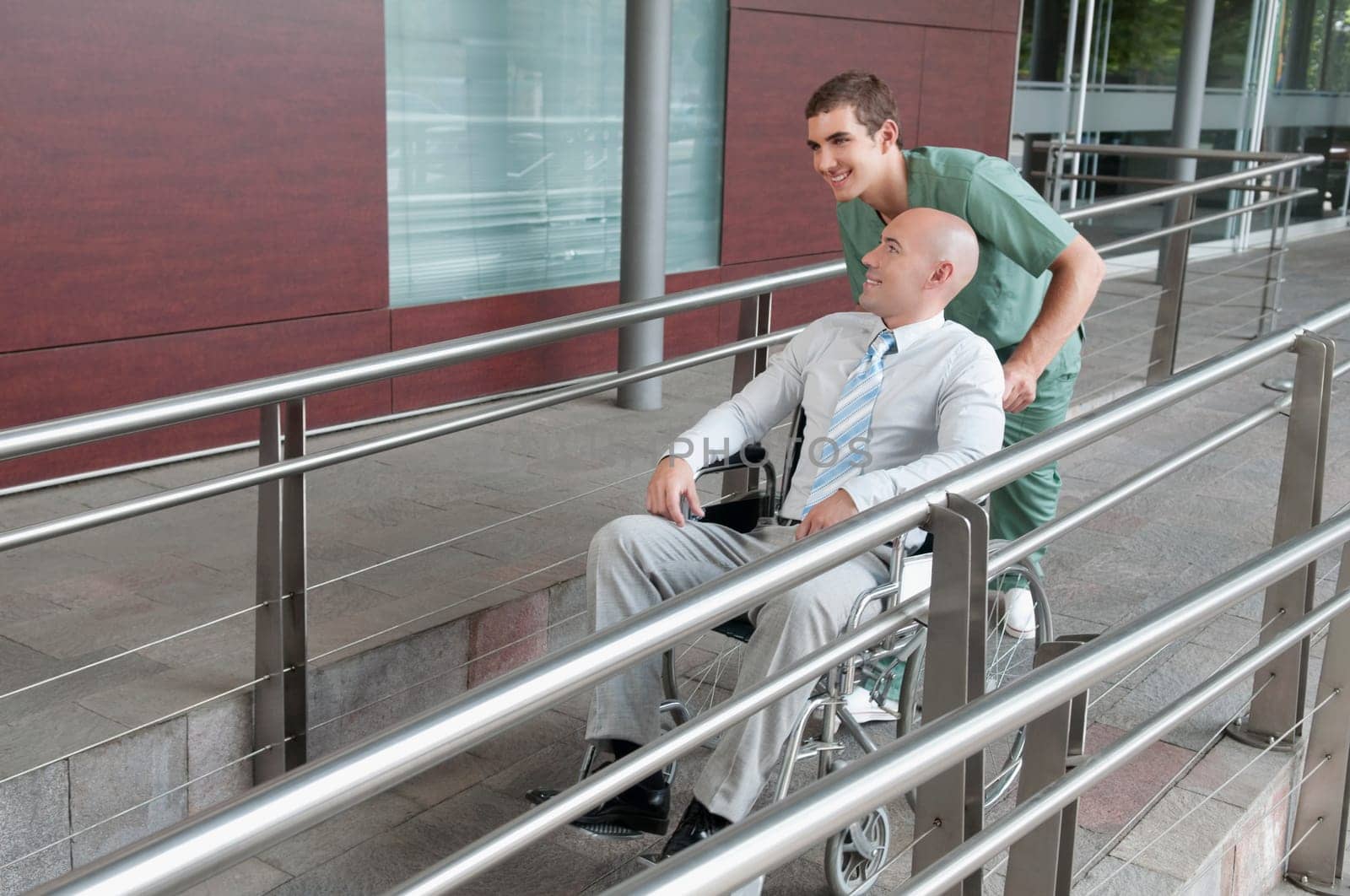 Male nurse pushing a man in wheelchair