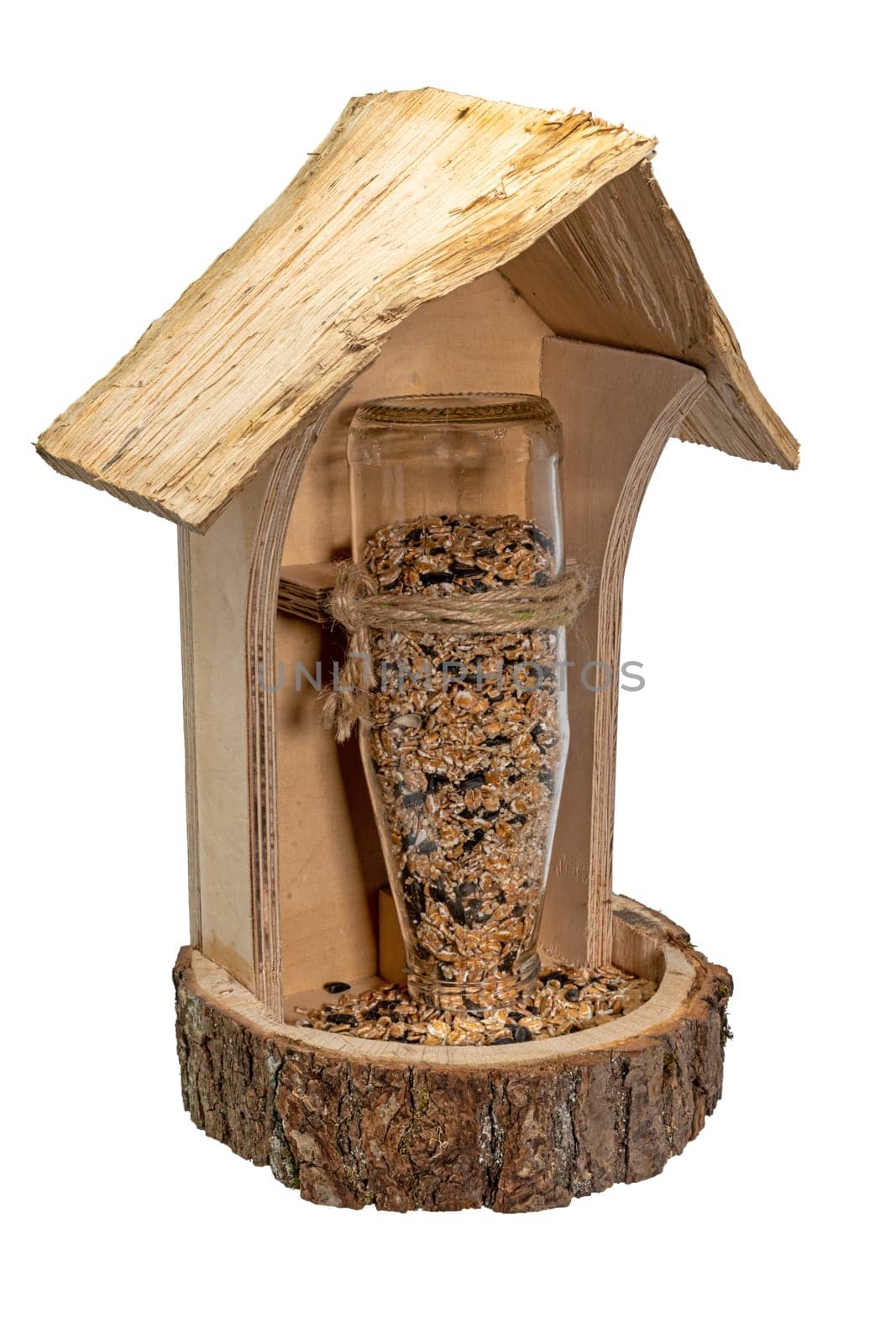 Self-made wooden bird feeder with glass bottle and bird seed i