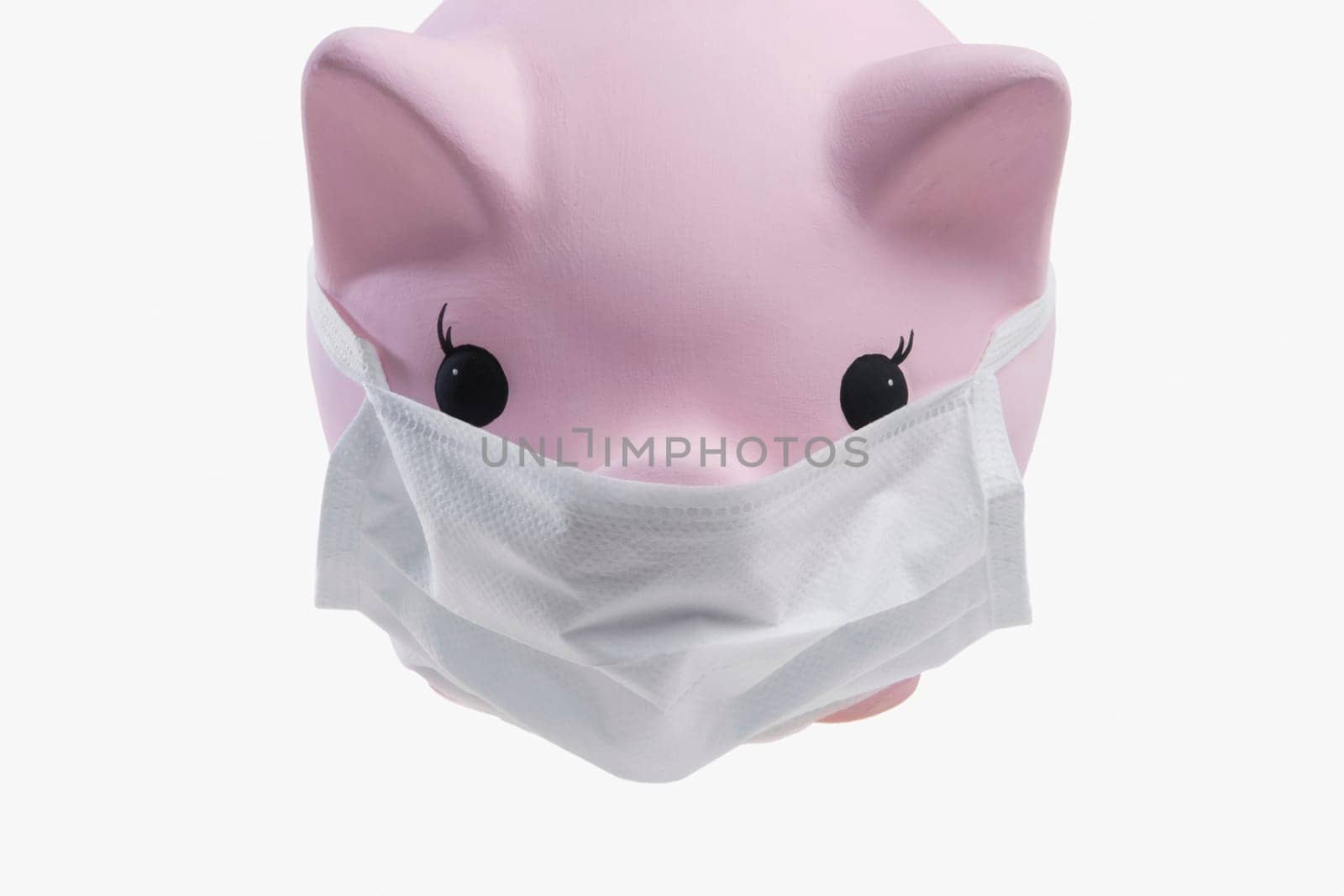 Close_up of a piggy bank wearing flu mask