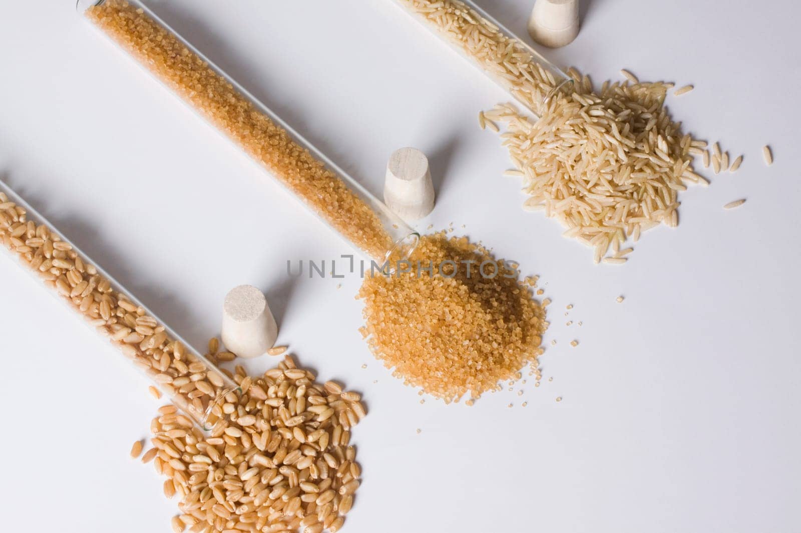 High angle view of brown rice and sugar with wheat in test tubes