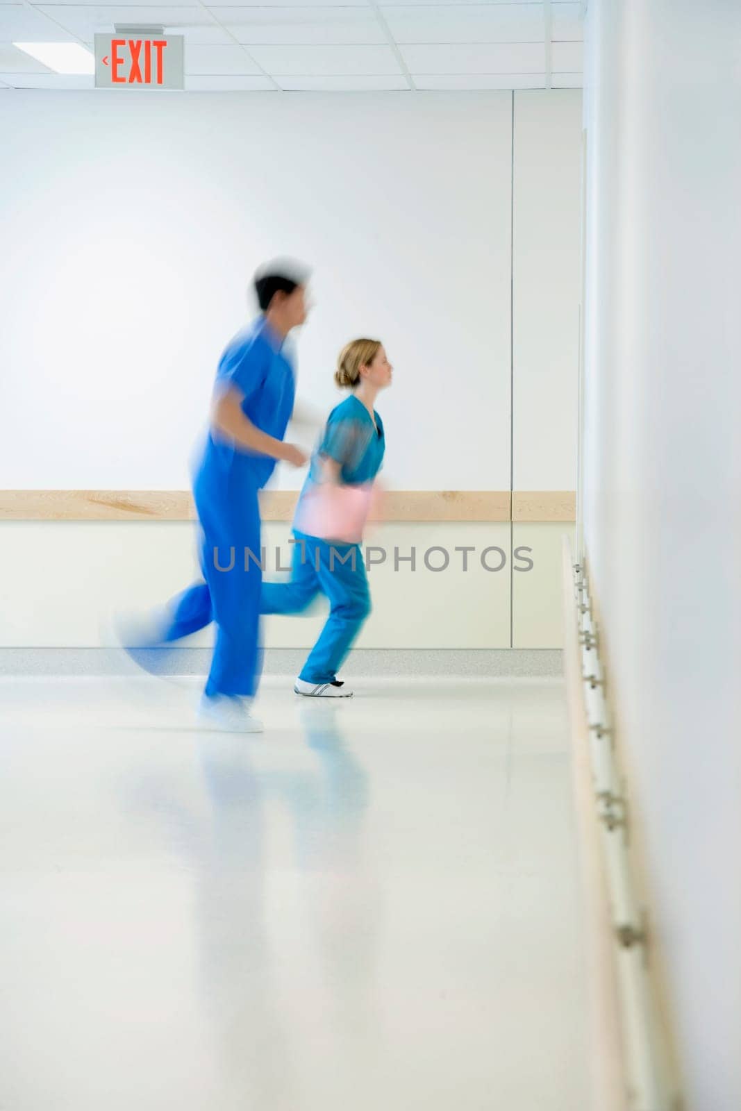 Two doctors running in a hospital corridor