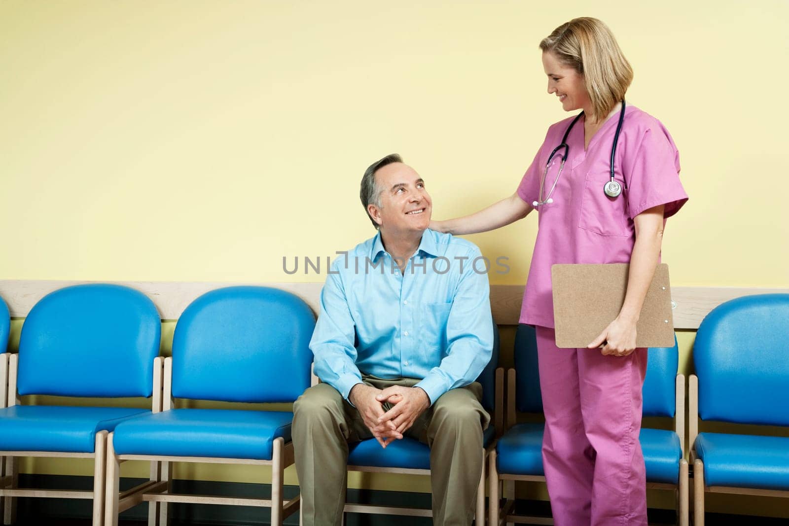 Female nurse talking to a patient in the waiting room
