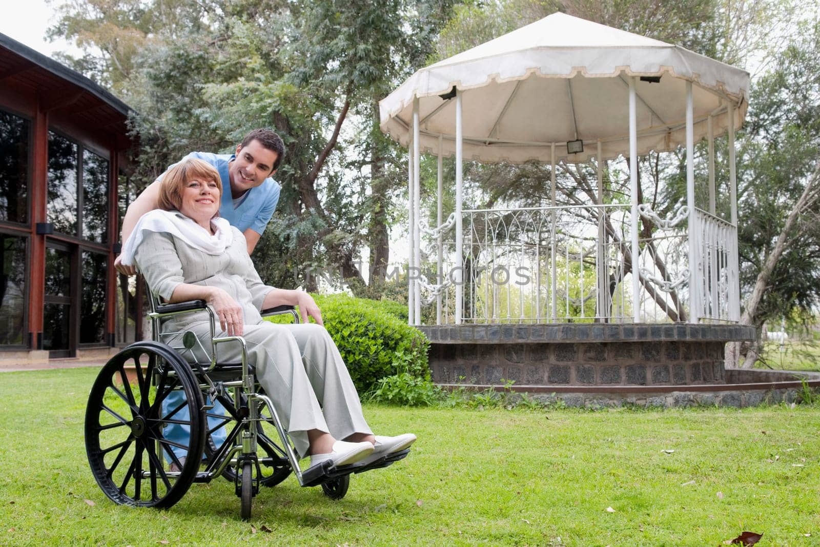 Healthcare worker pushing a woman sitting in a wheelchair