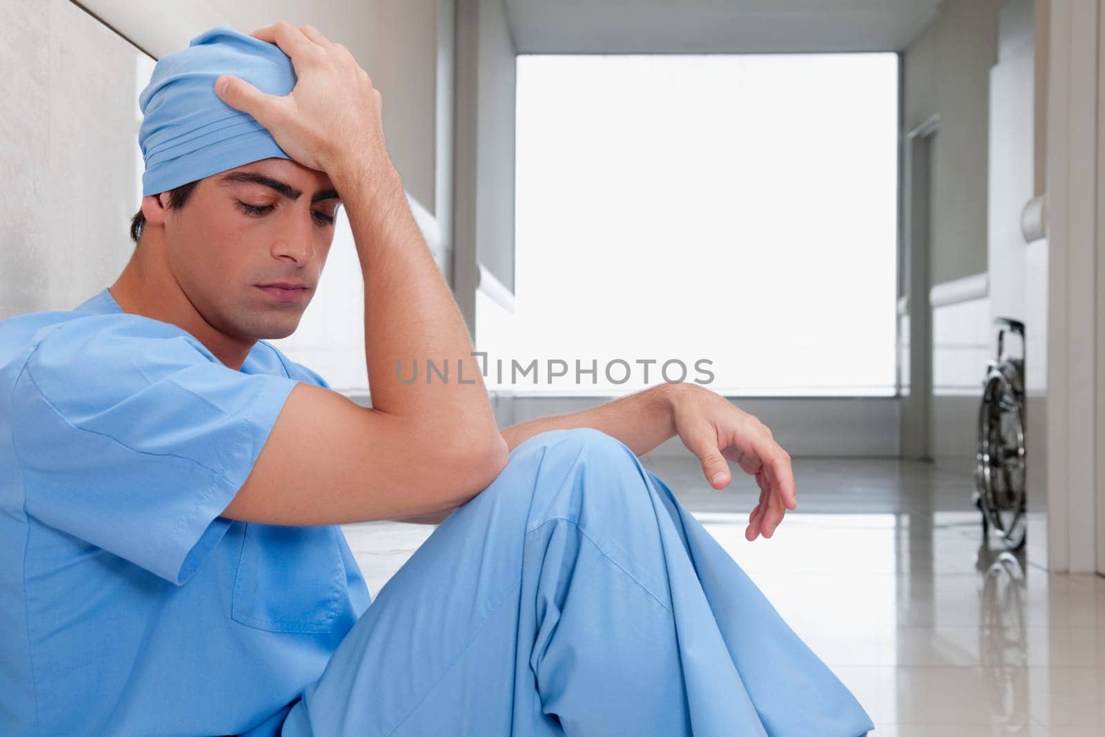 Surgeon sitting on the floor looking depressed