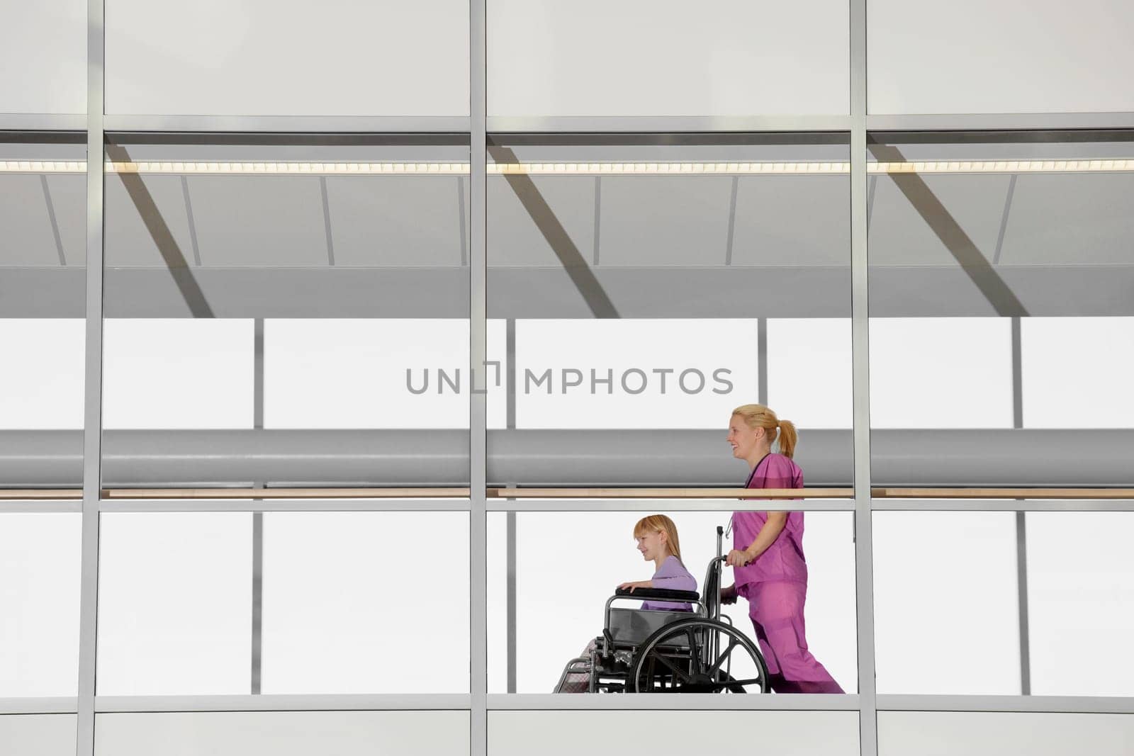 Female doctor pushing a patient in a wheelchair