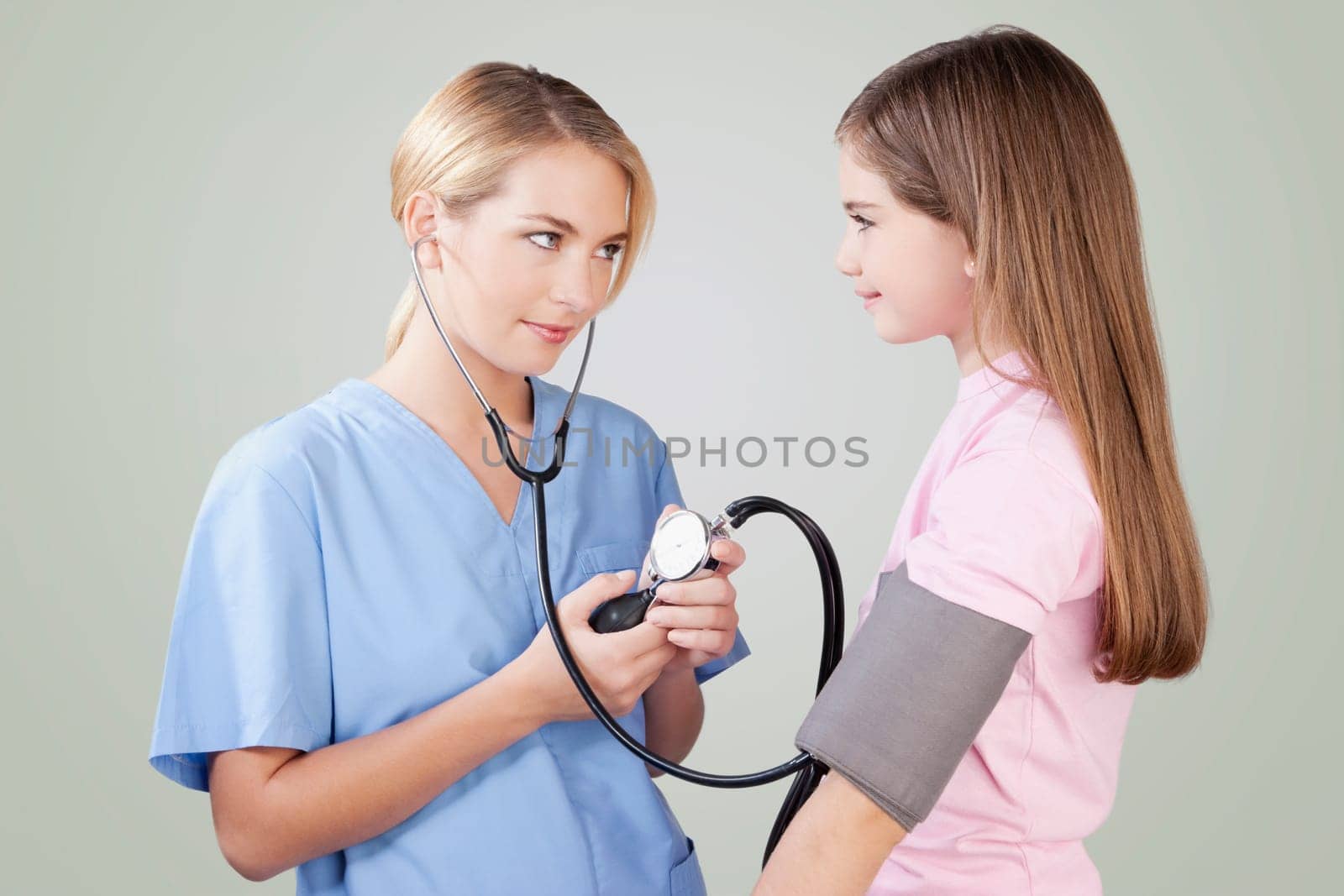 Female nurse checking the blood pressure of a girl