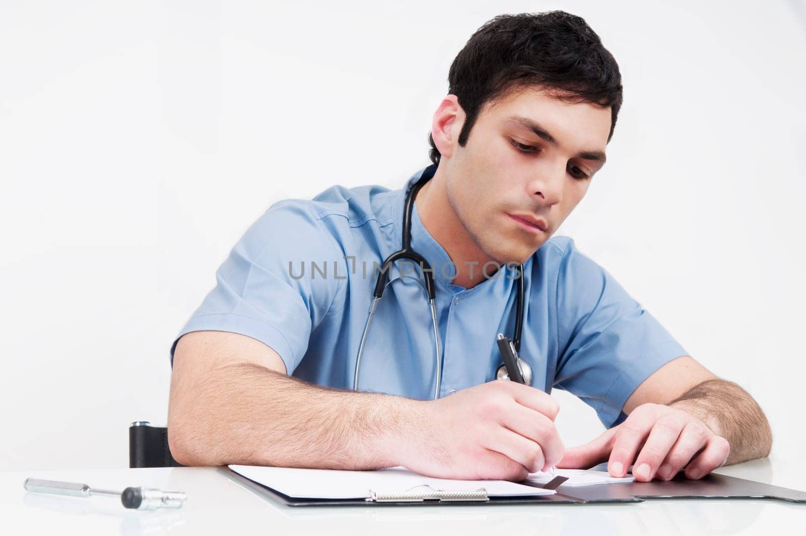 Doctor sitting at a table and writing in a file