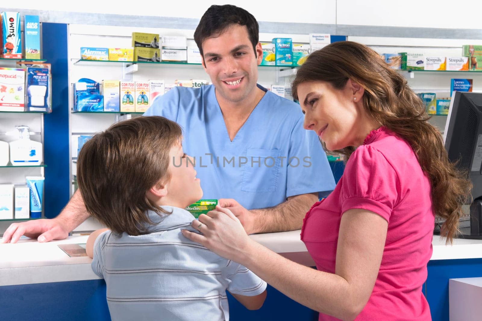 Pharmacist looking at boy standing with his mother