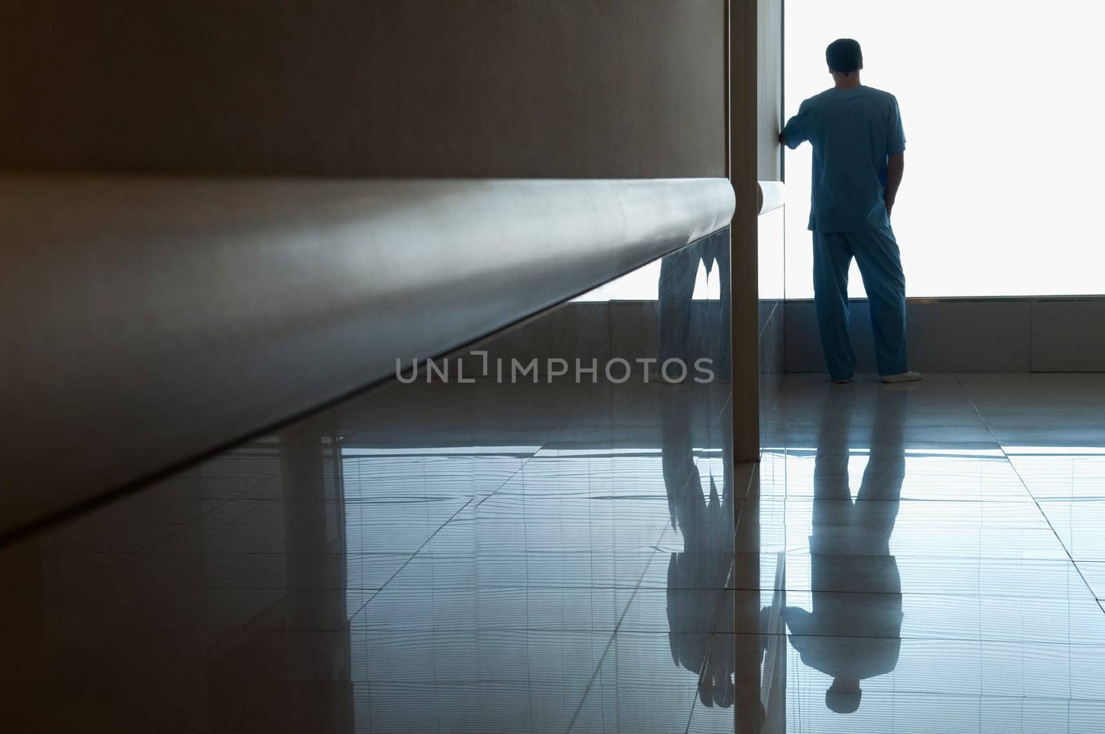 Surgeon looking through a window in a hospital