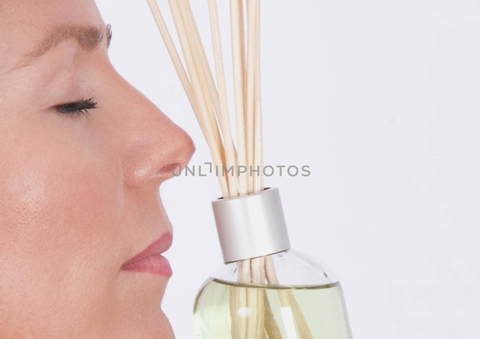 Woman smelling aromatherapy oil with incenses