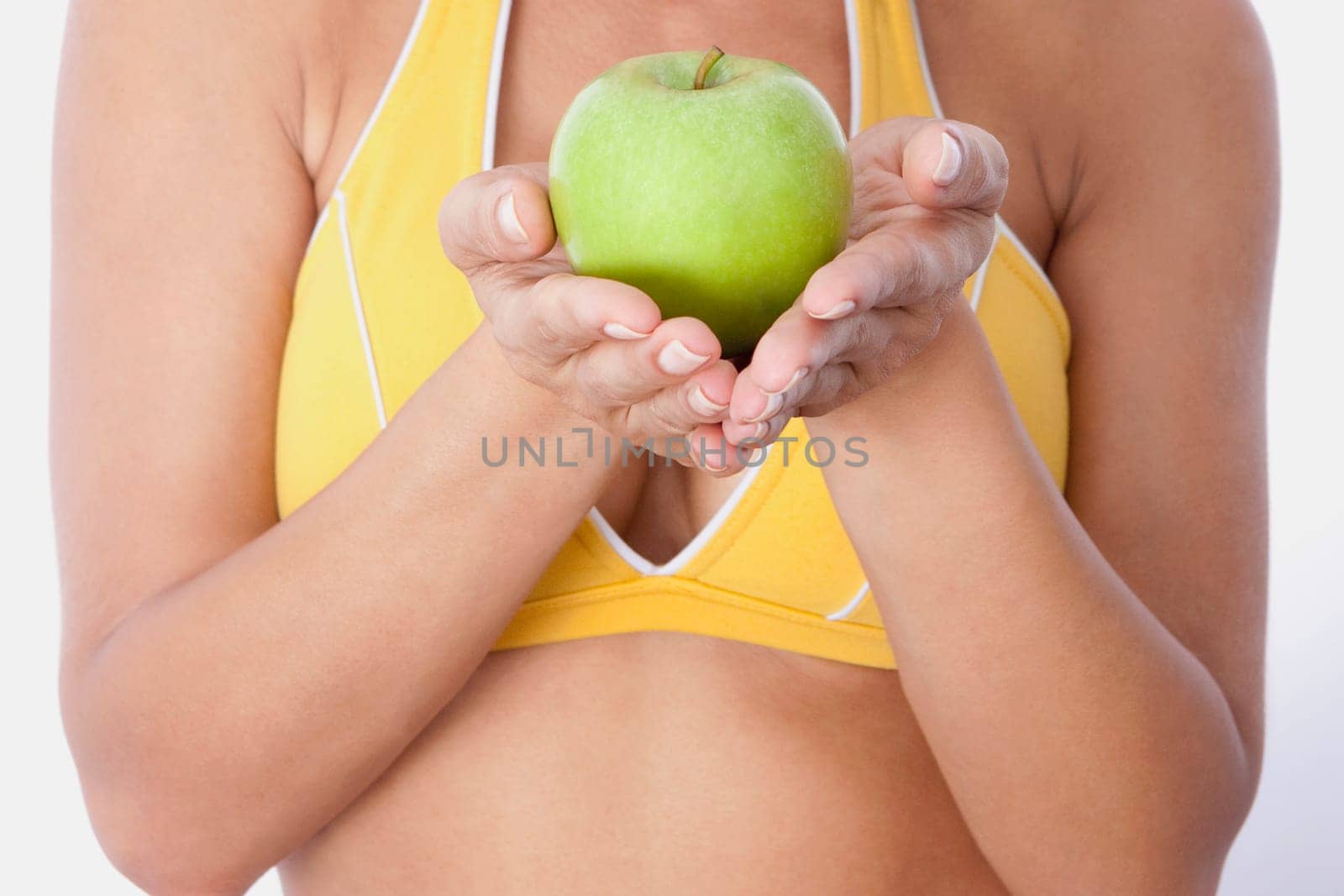Mid section view of a woman holding a green apple