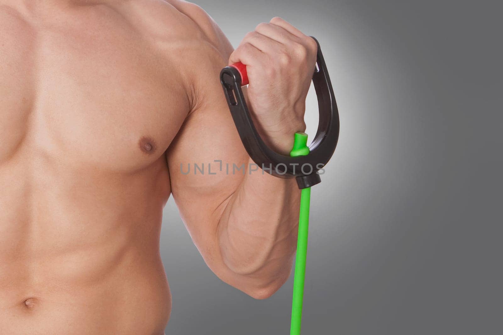Mid section view of a man exercising with resistance band