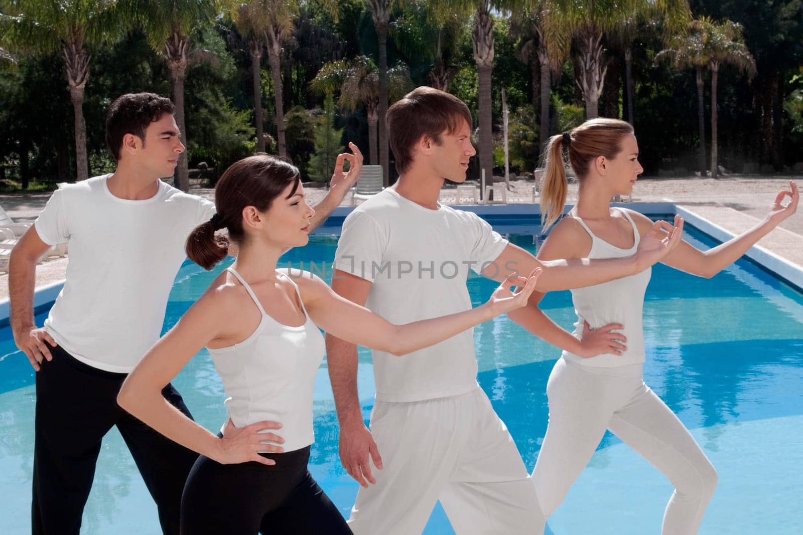 Four friends exercising at the poolside