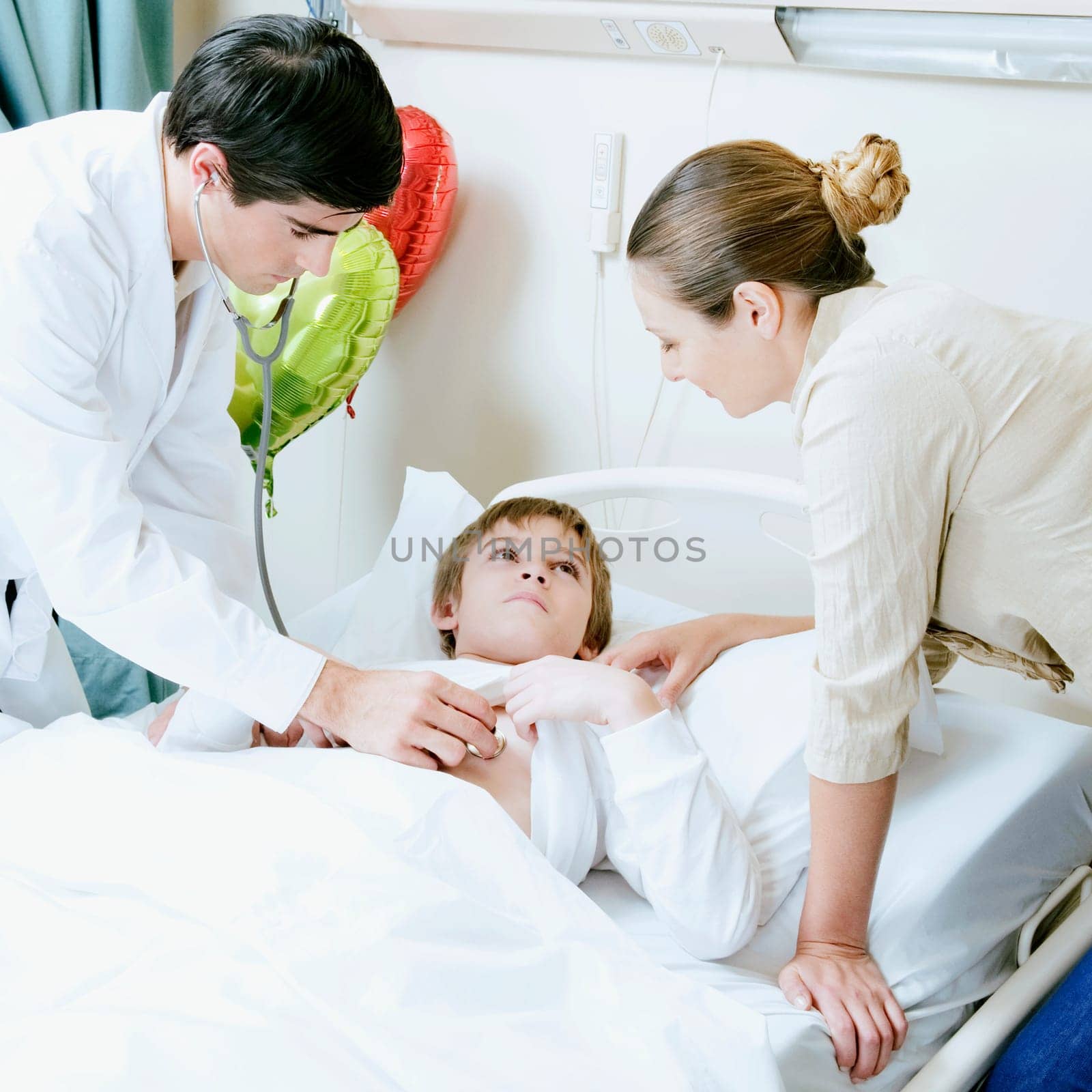 Boy on a hospital bed being examined by a doctor
