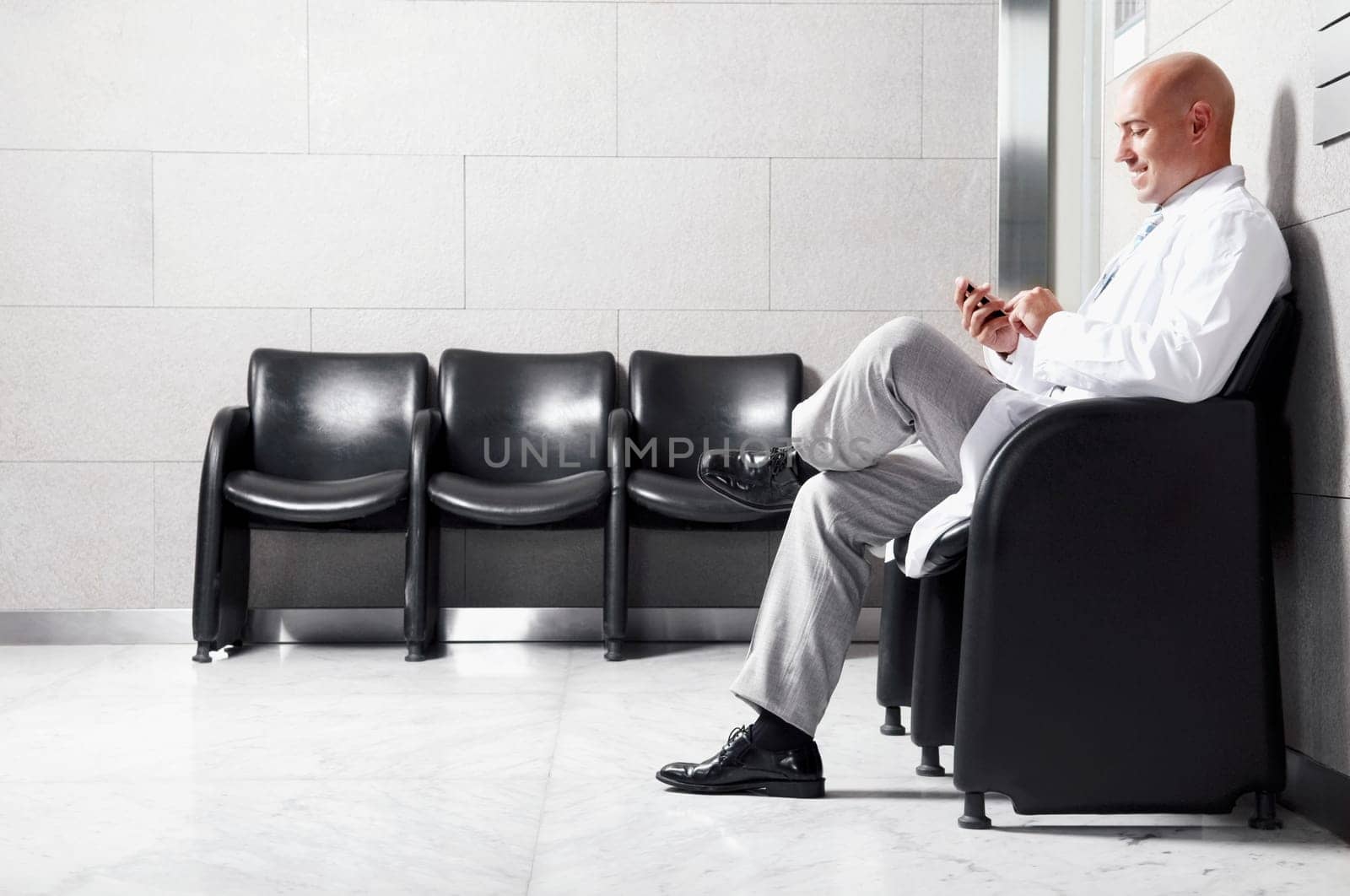 Doctor text messaging on a mobile phone