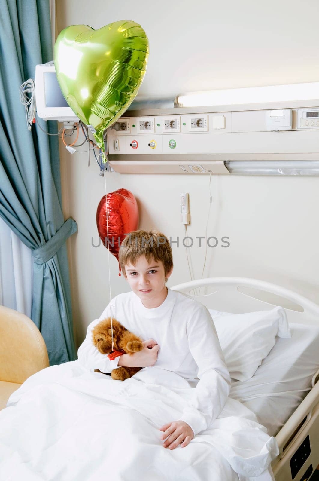 Portrait of a boy sitting on a hospital bed