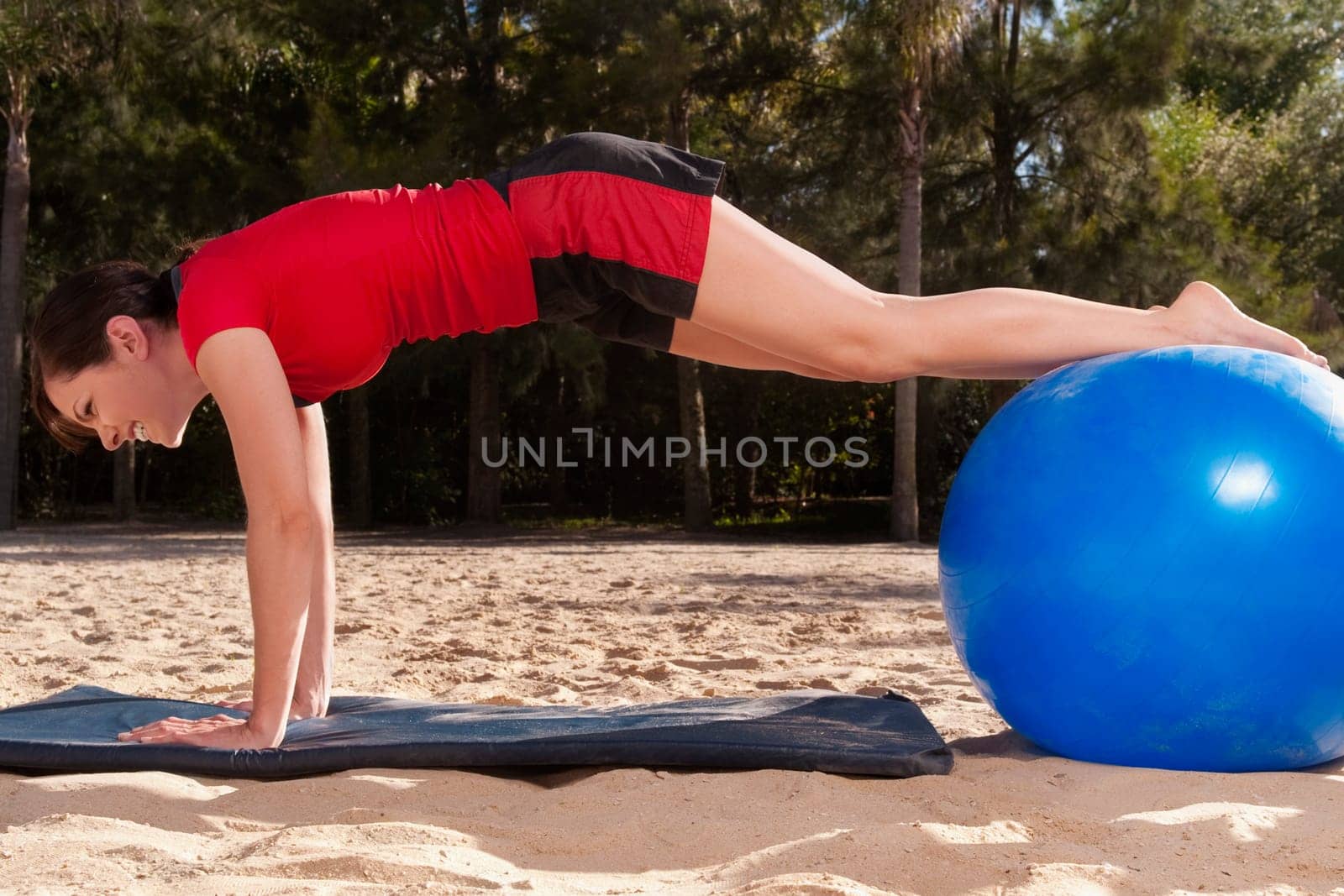 Woman exercising with a fitness ball on the beach