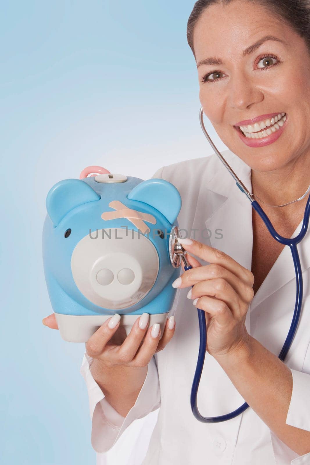Female doctor examining a piggy bank with a stethoscope