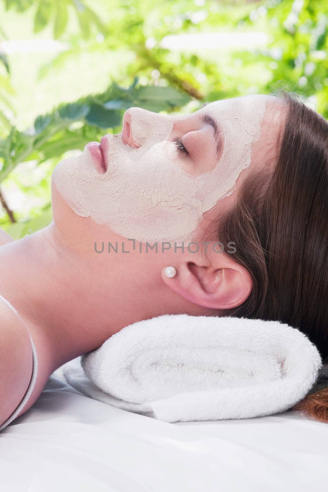 Woman with facial mask lying on a massage table