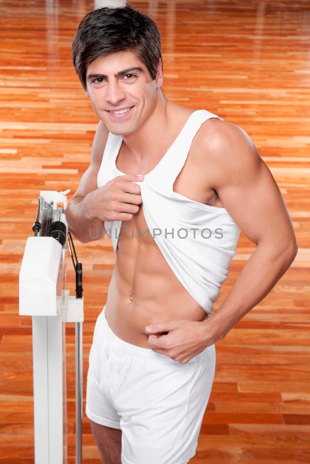 Portrait of a man pinching his waist and smiling